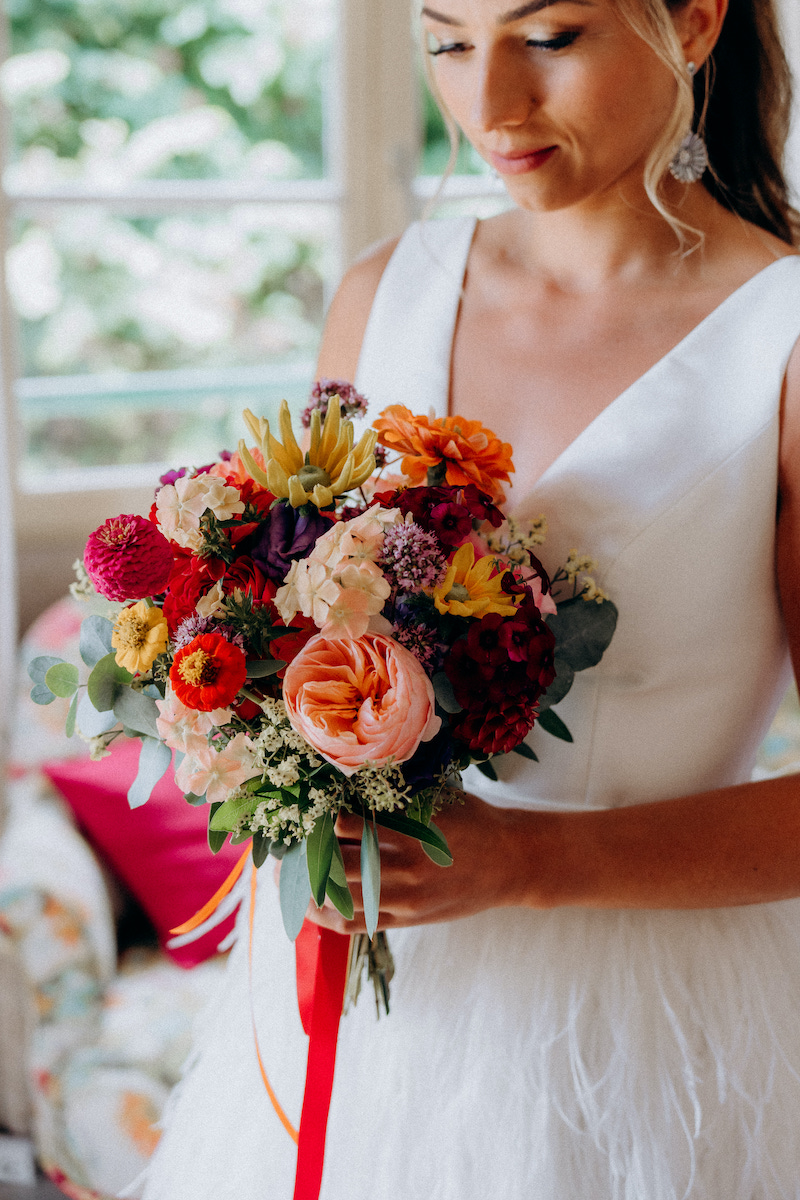 Une mariée et son bouquet de fleurs coloré