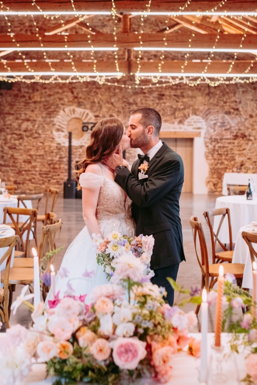 Un couple de mariés qui s'embrassent dans leur salle de réception